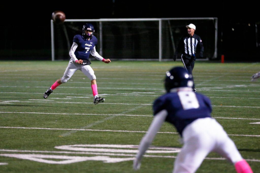 Arlington quarterback Leyton Martin watches as his throw makes it to receiver Kaid Hunter for a completion against Monroe on Friday, Oct. 27, 2023, at Arlington High School in Arlington, Washington. (Ryan Berry / The Herald)
