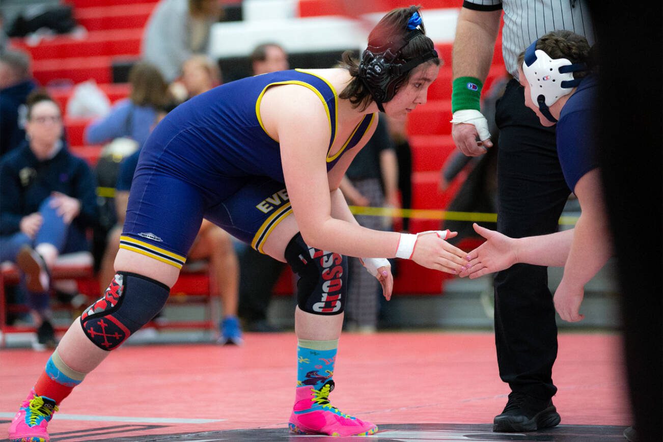 Everett’s Mia Cienega shakes hands with Arlington’s Janay Beckman before claiming a victory by pin during the 3A/4A Girls Region 1 Wrestling Tournament on Saturday, Feb. 11, 2023, at Snohomish High School in Snohomish, Washington. (Ryan Berry / The Herald)