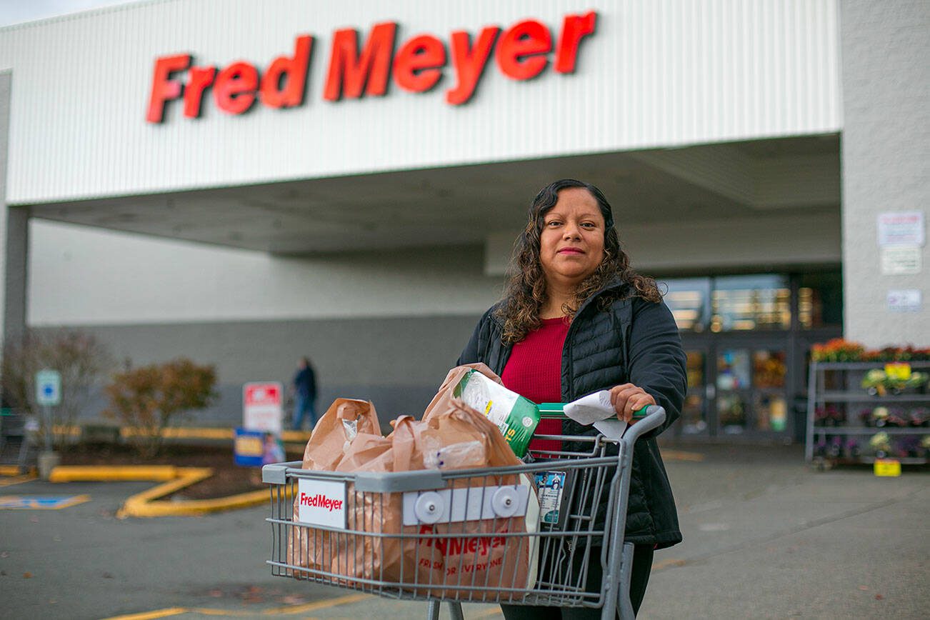 Silvia Mendoza, 41, exits Fred Meyer with ingredients to make tinga for her family Thursday, Nov. 2, 2023, on Evergreen Way in Everett, Washington. Mendoza doesn’t own a car, so most days she walks from her Casino Road apartment to pick up food and other necessities. Without the South Everett Fred Meyer, she and thousands of others would have no major grocery store within walking distance. (Ryan Berry / The Herald)