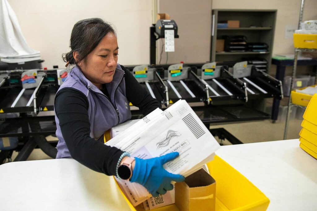 Veteran election worker Tien Mai moves sealed ballots from a sorting machine while working at the Snohomish County Auditor’s office on Friday, Nov. 3, 2023, in downtown Everett, Washington. (Ryan Berry / The Herald)
