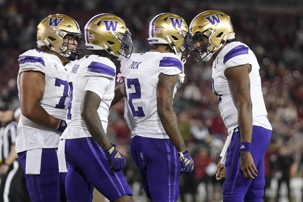 Washington wide receiver Ja’Lynn Polk (2) is congratulated by quarterback Michael Penix Jr., right, after scoring against Stanford during a game Oct. 28 in Stanford, Calif. (AP Photo/Jeff Chiu)
