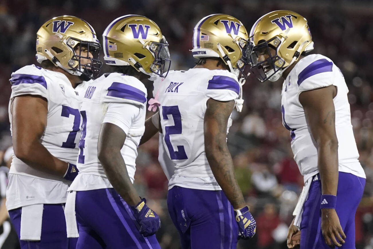 Washington wide receiver Ja'Lynn Polk (2) is congratulated by quarterback Michael Penix Jr., right, after scoring against Stanford during the second half of an NCAA college football game in Stanford, Calif., Saturday, Oct. 28, 2023. (AP Photo/Jeff Chiu)