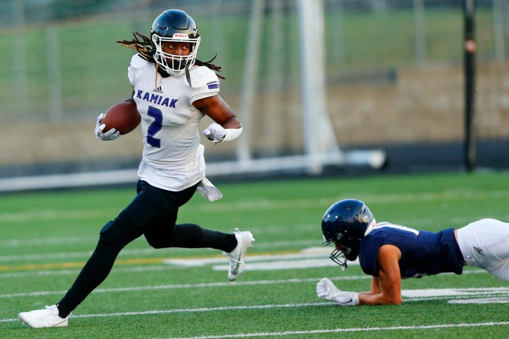 Kamiak junior T’Andre Waverly turns upfield after getting past a defender against Arlington on Sept. 1 in Arlington. (Ryan Berry / The Herald)
