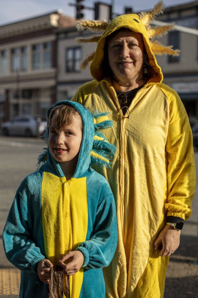 Kannon S., 6, left, and Sheila S., right, pose for a photo during the Downtown Trick or Treat event in Monroe, Washington on Tuesday, Oct. 31, 2023. Children, teens and families walked Main Street to collect candy from local businesses. Dogs sported costumes as well and decorations adorned buildings. (Annie Barker / The Herald)
