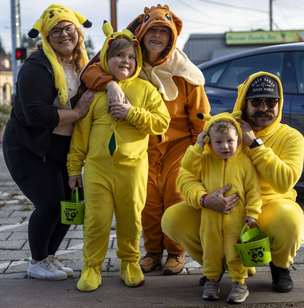The Pastrana-Kolczak family poses for a photo left to right: Sierra, Axel, Diane, Enzo and Enrique during the Downtown Trick or Treat event in Monroe, Washington on Tuesday, Oct. 31, 2023. Children, teens and families walked Main Street to collect candy from local businesses. Dogs sported costumes as well and decorations adorned buildings. (Annie Barker / The Herald)
