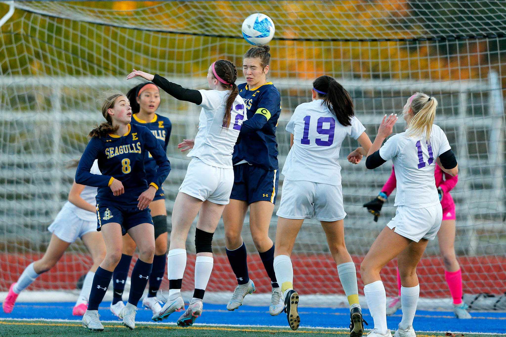 Everett senior defender Lanie Thompson, center, tries to head away a corner kick from in front of her team’s goal during a district playoff matchup against Oak Harbor on Thursday, Nov. 2, 2023, at Shoreline Stadium in Shoreline, Washington. (Ryan Berry / The Herald)