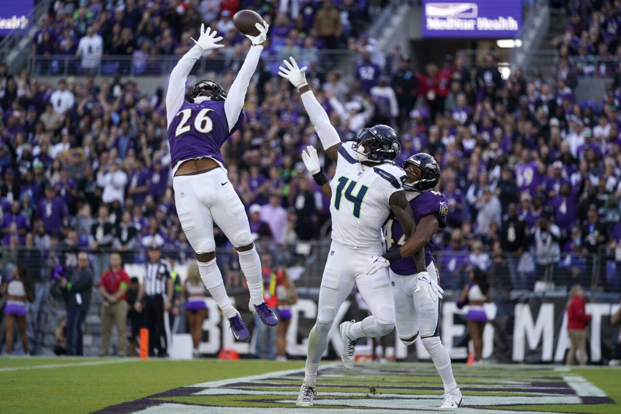 Baltimore Ravens safety Geno Stone (26) and cornerback Marlon Humphrey, right, break up a pass intended for Seattle Seahawks wide receiver DK Metcalf (14) during the second half of a game Sunday in Baltimore. (AP Photo/Alex Brandon)