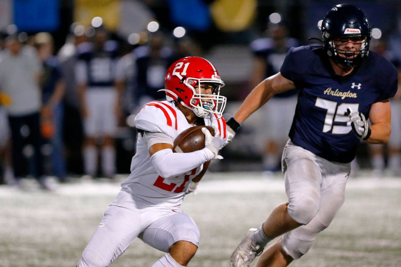 Marysville Pilchuck senior Kenai Sinaphet tries to get around the edge on a handoff against Arlington on Friday, Oct. 6, 2023, at Arlington High School in Arlington, Washington. (Ryan Berry / The Herald)