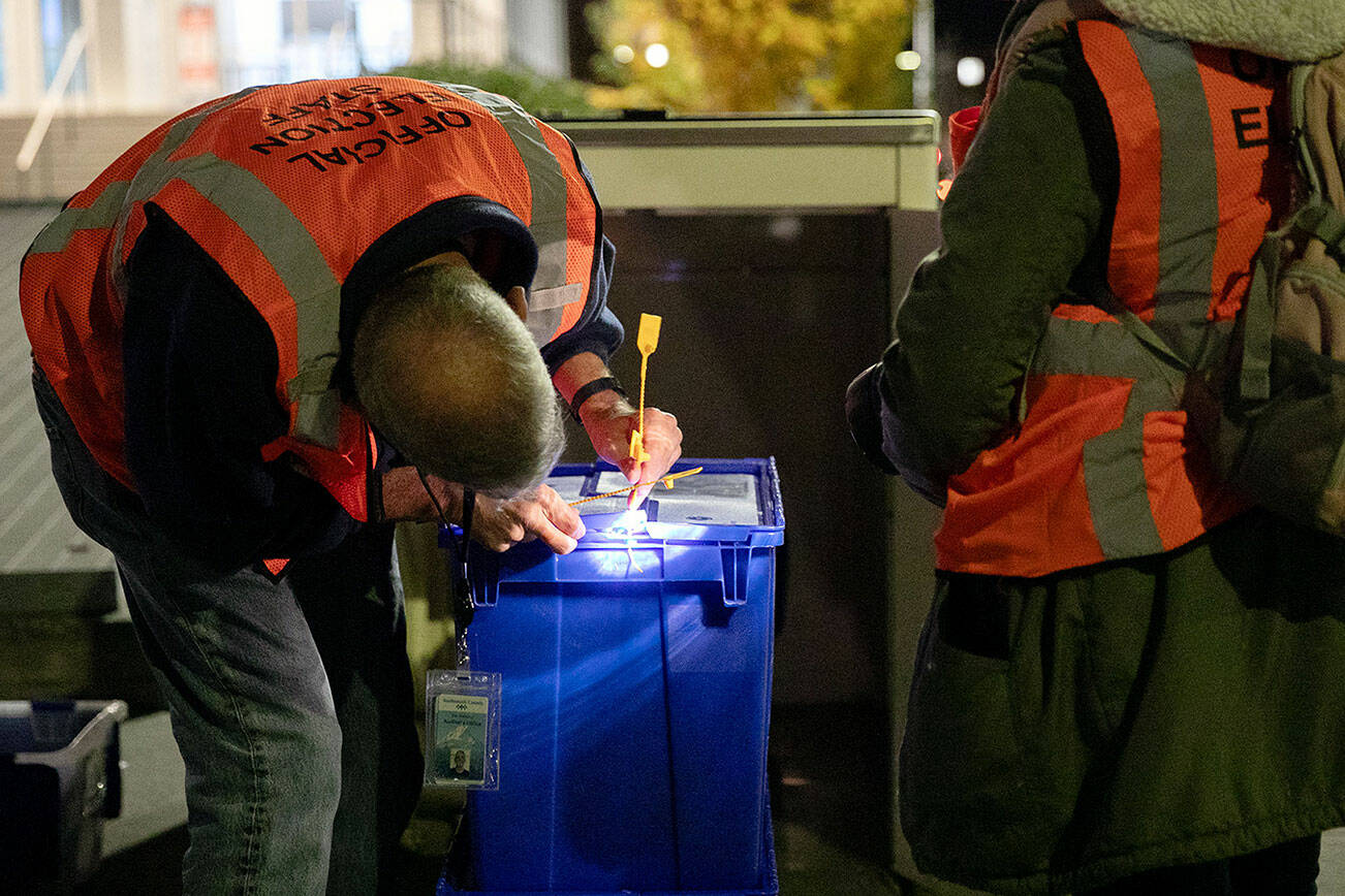 Two election workers seal up boxes of ballots after closing the county courthouse ballot box at 8 p.m. Tuesday, Nov. 7, 2023, in downtown Everett, Washington. (Ryan Berry / The Herald)