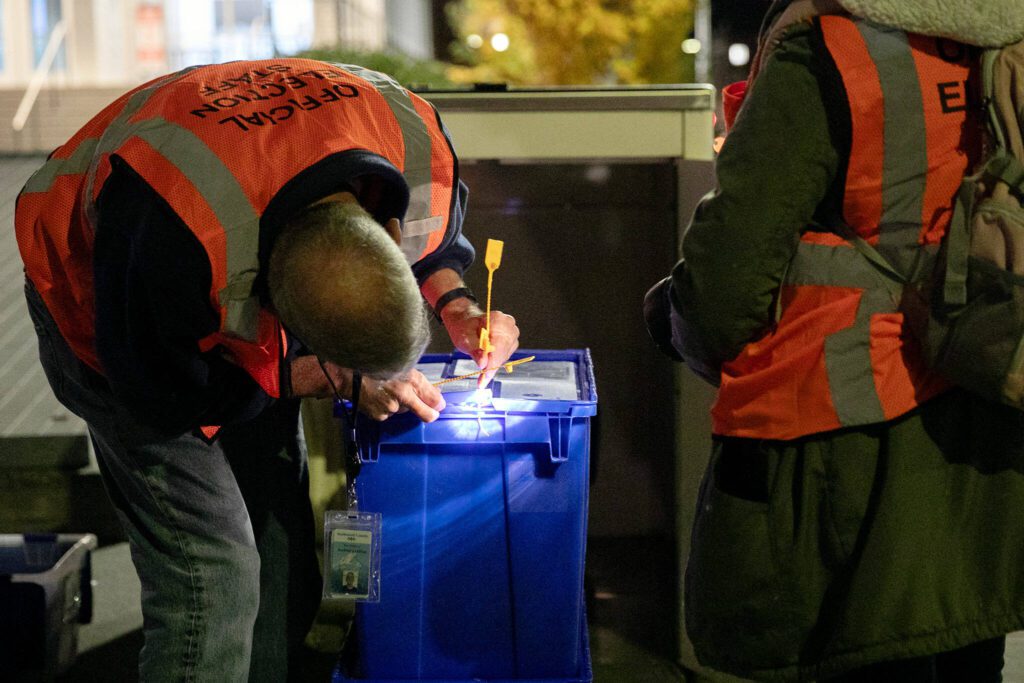Two election workers seal up boxes of ballots after closing the county courthouse ballot box at 8 p.m. Tuesday, Nov. 7, 2023, in downtown Everett, Washington. (Ryan Berry / The Herald)
