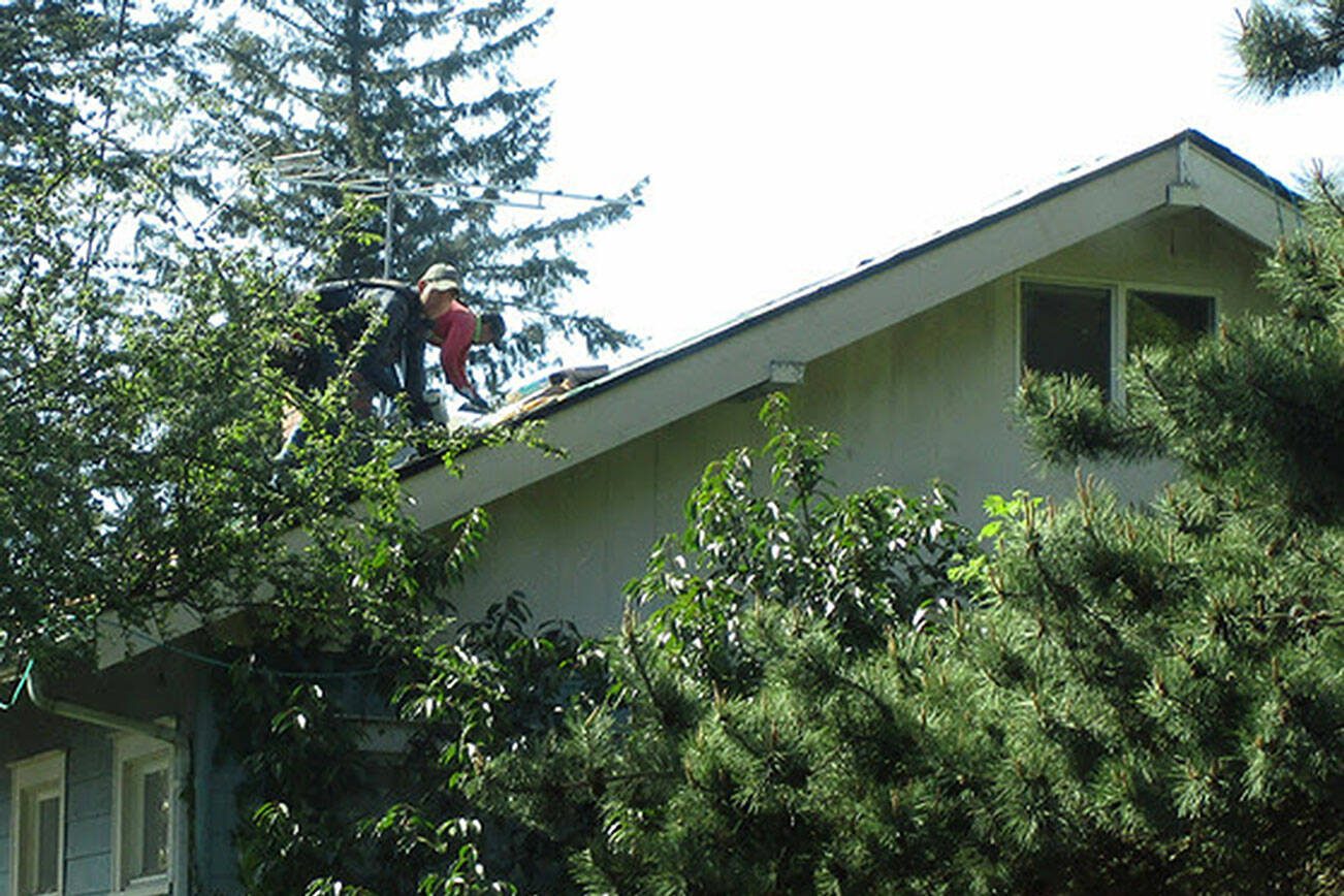 State regulators photographed these Allways Roofing employees working on top of a house in Mount Vernon, Wash. without wearing proper fall protection. (Washington State Department of Labor & Industries)