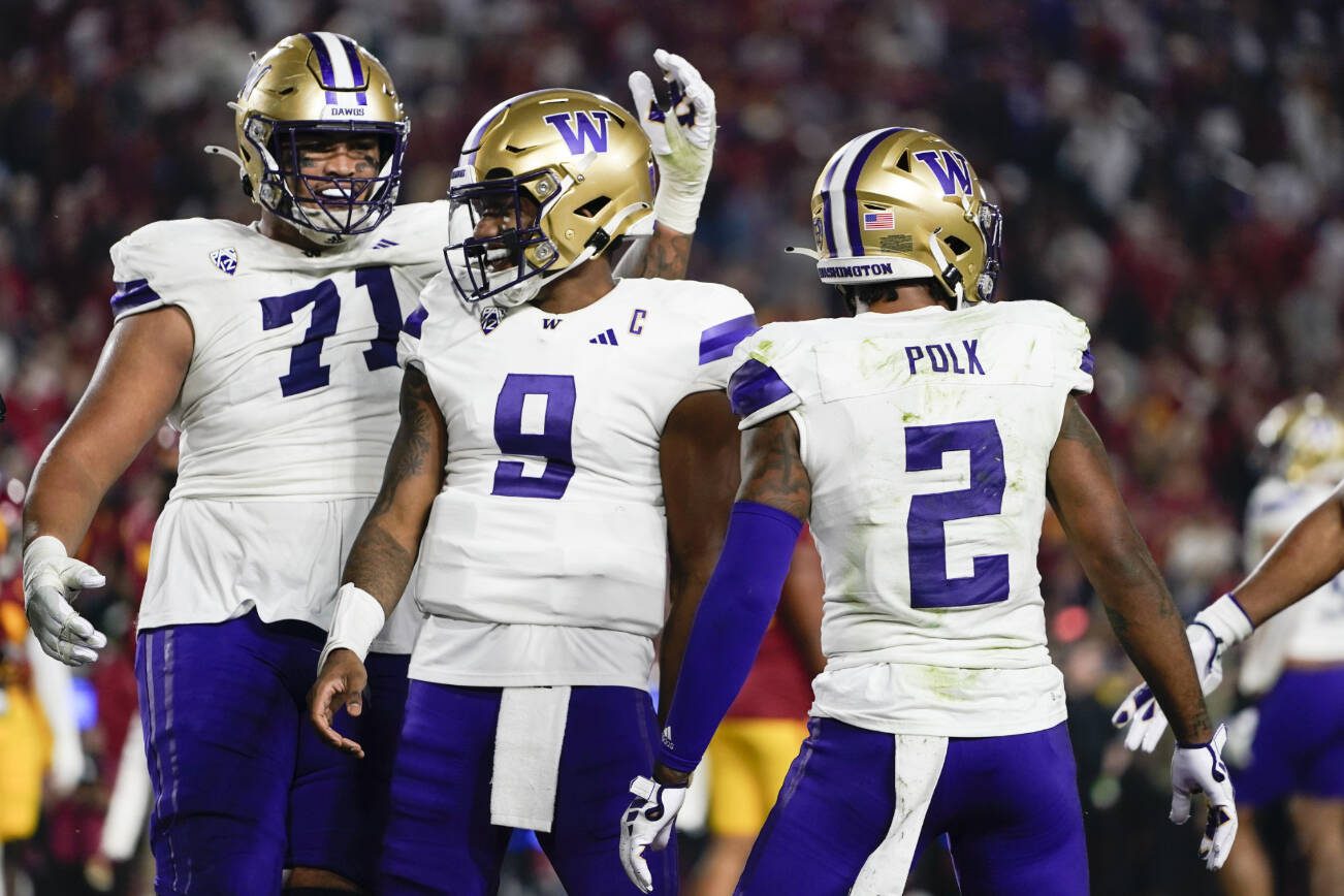 Washington offensive lineman Nate Kalepo (71) and quarterback Michael Penix Jr. (9) celebrate after a touchdown by wide receiver Ja'Lynn Polk (2) during the first half of the team's NCAA college football game against Southern California, Saturday, Nov. 4, 2023, in Los Angeles. (AP Photo/Ryan Sun)