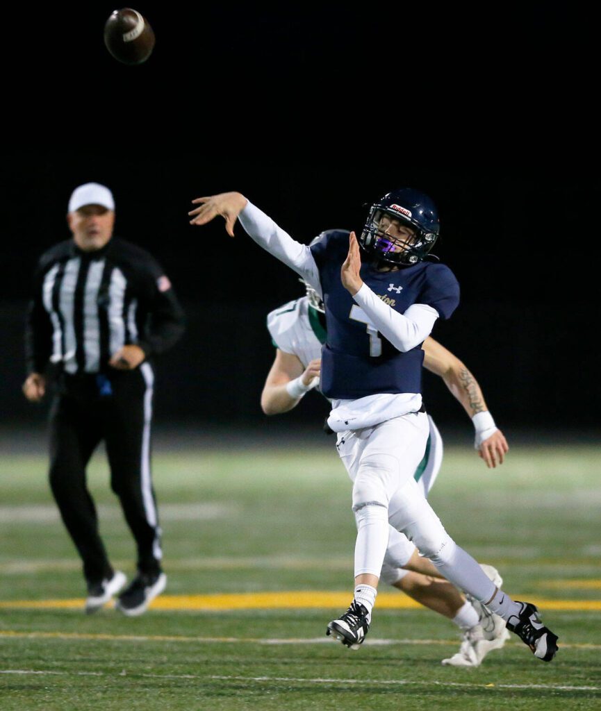 Arlington quarterback Leyton Martin throws on the run against Ridgeline during a playoff matchup Friday, Nov. 10, 2023, at Arlington High School in Arlington, Washington. (Ryan Berry / The Herald)
