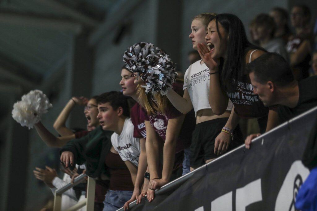 Fans cheer during the 3A girls state swim and dive championships at King County Aquatic Center in Federal Way, Washington on Saturday, Nov. 11, 2023. (Annie Barker / The Herald)
