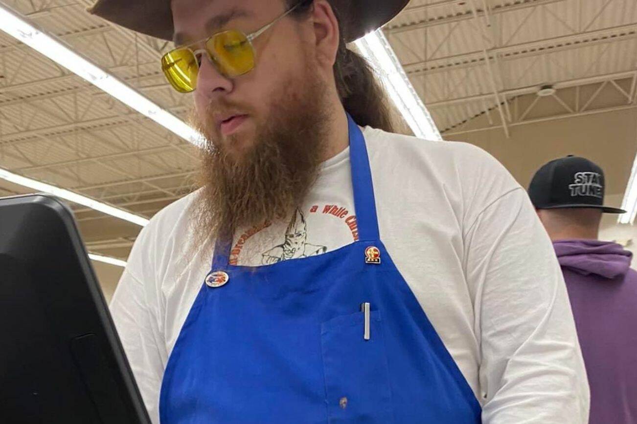 A Gold Bar Family Grocer employee checks out customers while wearing a Ku Klux Klan shirt that reads "I'm dreaming of a white Christmas," KKK pins, and a loaded holster in Gold Bar, Washington. The photo was posted to the Gold Bar Facebook group on Saturday, Nov. 11, 2023. (Provided photo)