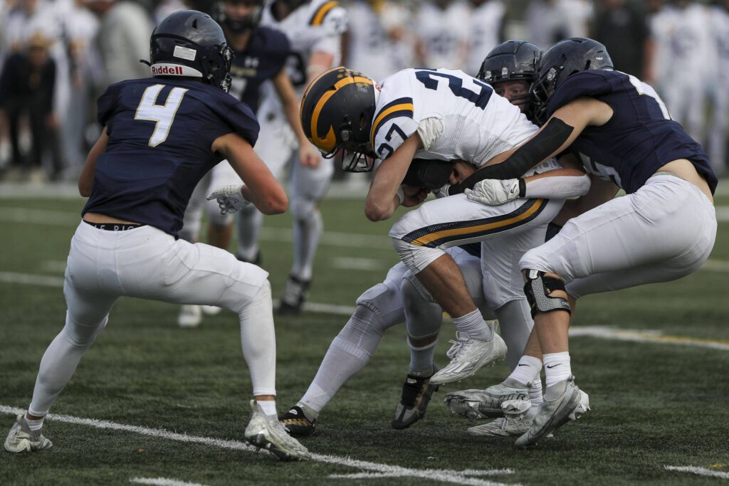 Bellevue’s Blake Teets (27) is tackled during the Arlington and Bellevue Class 3A state quarterfinal game at Arlington High School in Arlington, Washington on Saturday, Nov. 18, 2023. Arlington lost, 35-17. (Annie Barker / The Herald)
