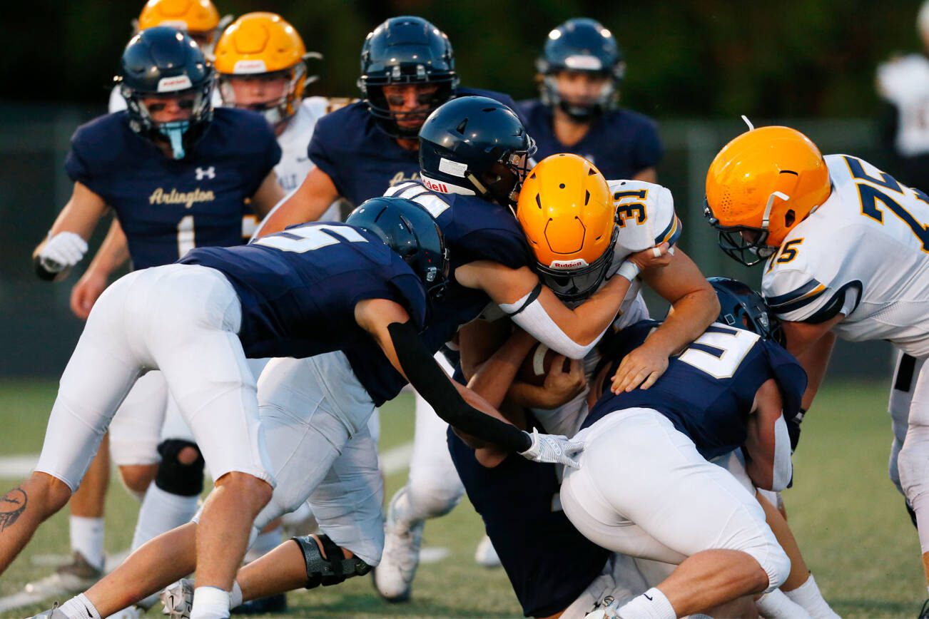 Arlington’s defense stuffs Ferndale running back Talan Bungard on Friday, Sept. 22, 2023, at Arlington High School in Arlington, Washington. (Ryan Berry / The Herald)