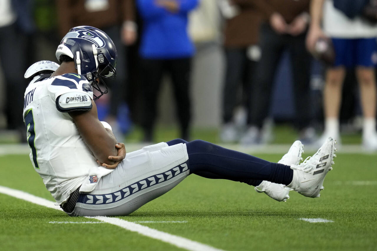 Seattle Seahawks quarterback Geno Smith sits on the field after being injured during the second half of a game against the Los Angeles Rams on Sunday in Inglewood, Calif. (AP Photo/Ashley Landis)