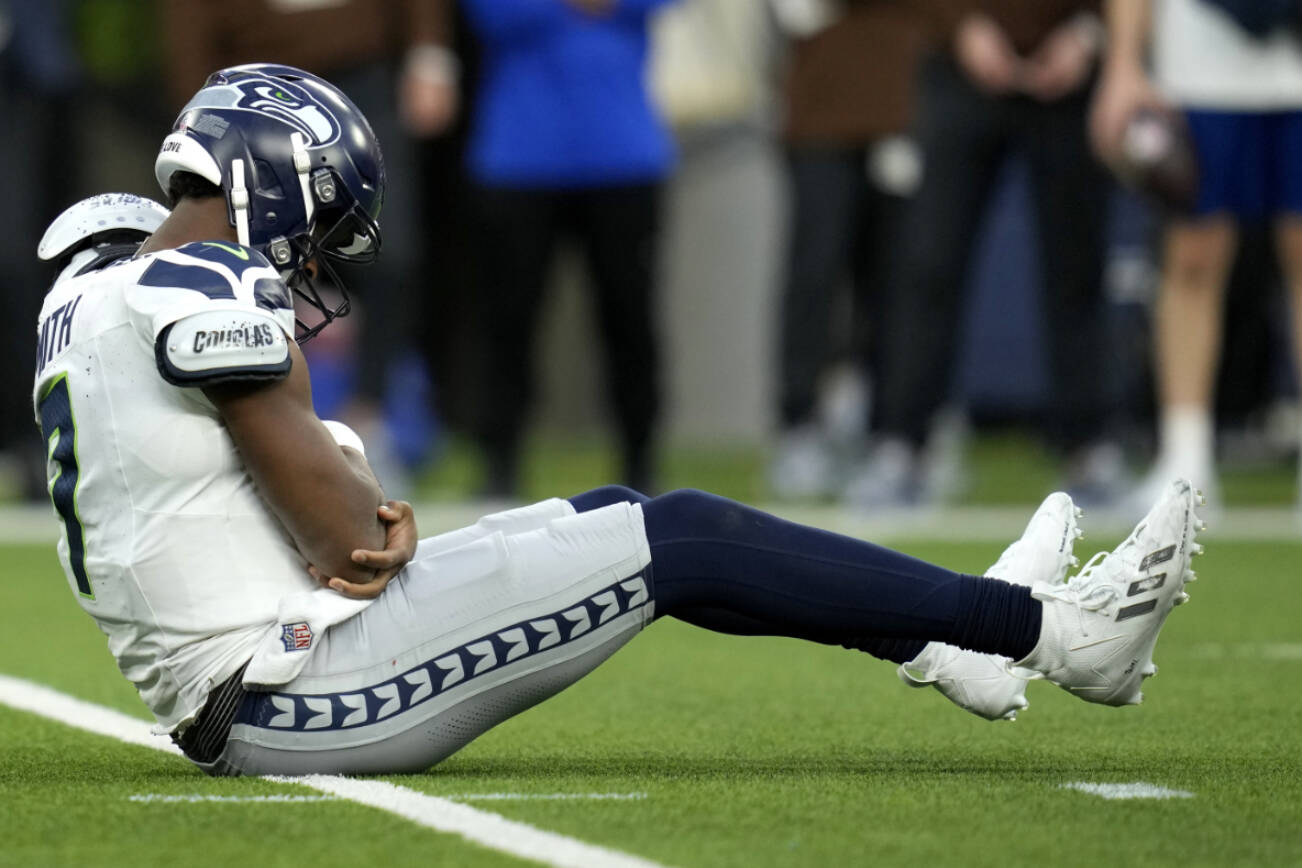 Seattle Seahawks quarterback Geno Smith (7) sits on the field after being injured during the second half of an NFL football game against the Los Angeles Rams Sunday, Nov. 19, 2023, in Inglewood, Calif. (AP Photo/Ashley Landis)