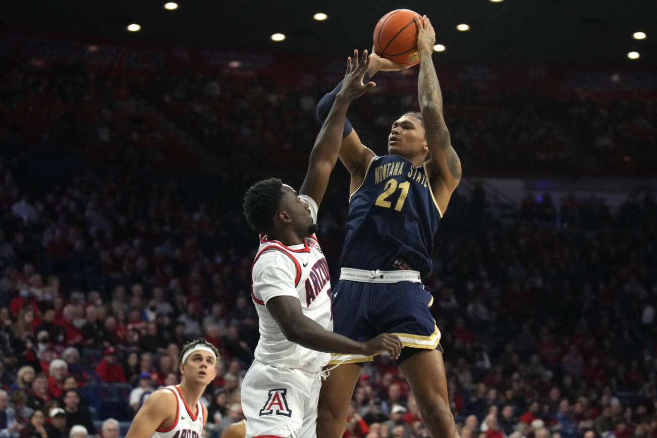 Montana State guard RaeQuan Battle (21) shoots over Arizona guard Courtney Ramey during the first half of an NCAA college basketball game, Tuesday, Dec. 20, 2022, in Tucson, Ariz. (AP Photo/Rick Scuteri)