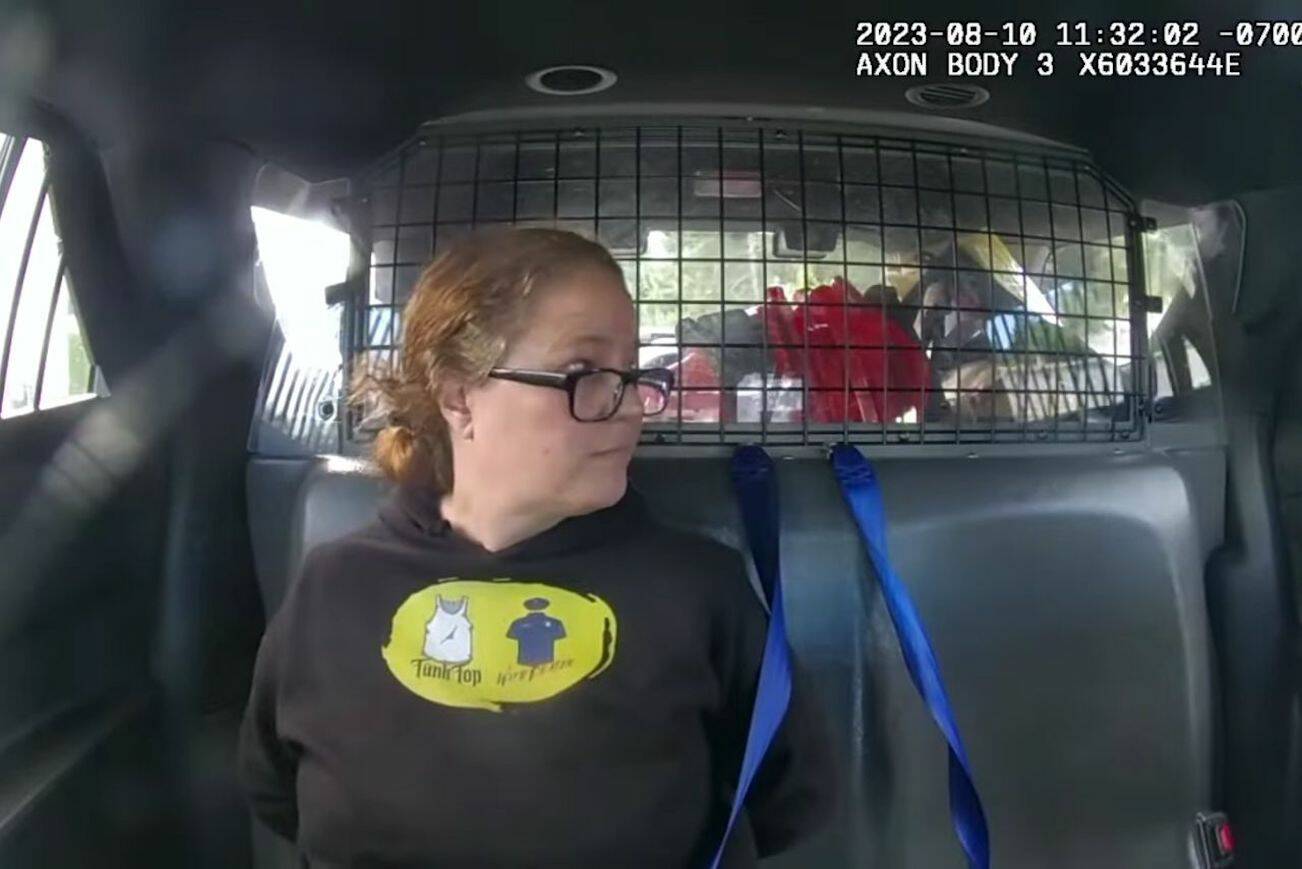 From the patrol car footage of Everett police officer Ryan Greely, Molly Wright sits in the back of a police car after being arrested for obstructing a law enforcement officer on Aug. 10, 2023 in Everett, Washington. (Screenshot from a video provided by Molly Wright)