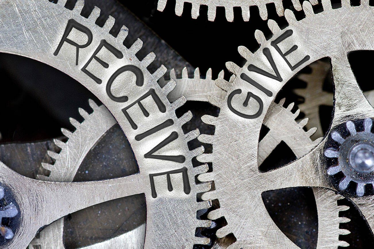 Macro photo of tooth wheel mechanism with imprinted RECEIVE, GIVE concept words