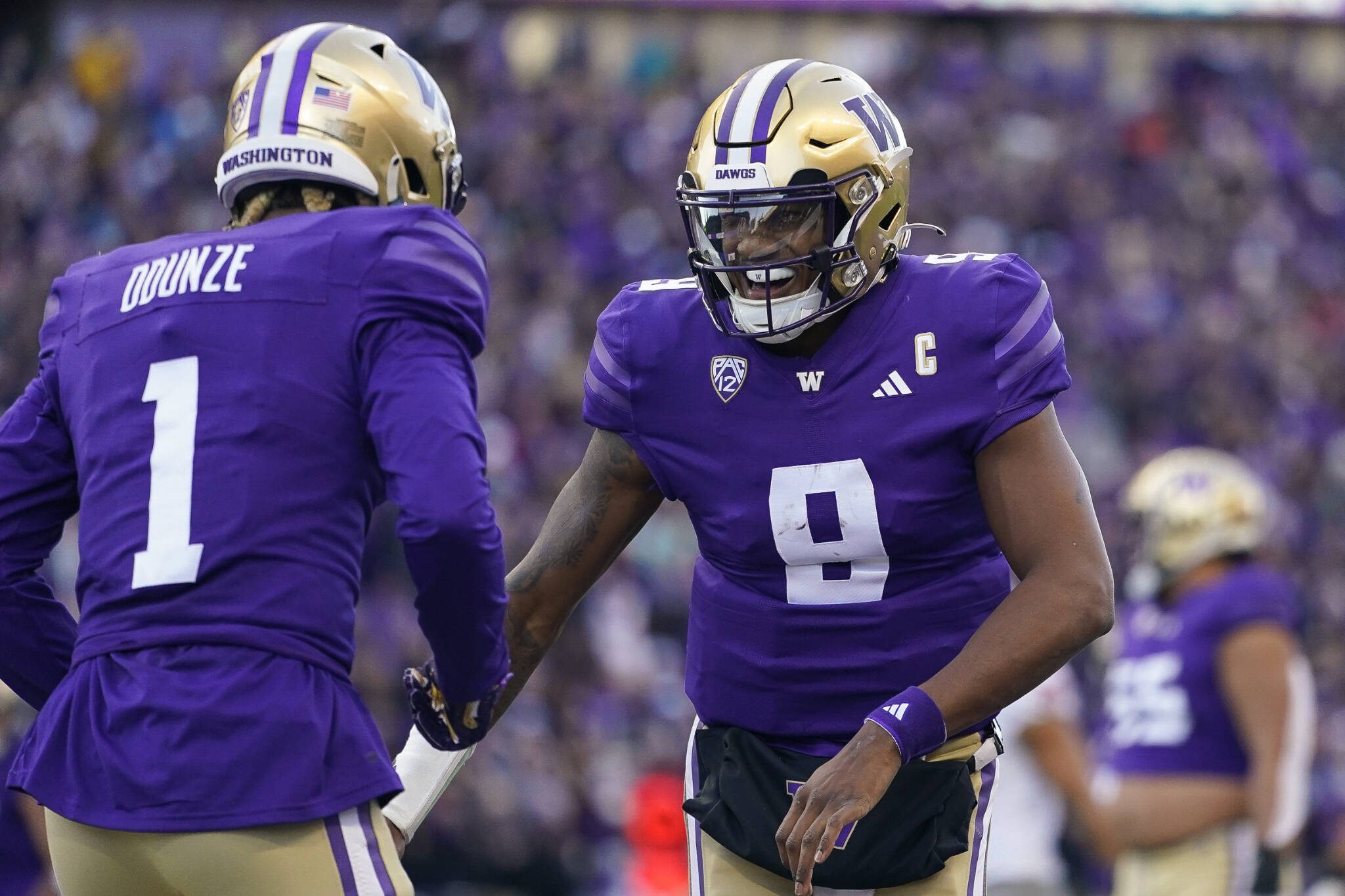 Washington quarterback Michael Penix Jr. (9) celebrates throwing a touchdown to wide receiver Rome Odunze (1) against Washington State during a game Saturday in Seattle. (AP Photo/Lindsey Wasson)