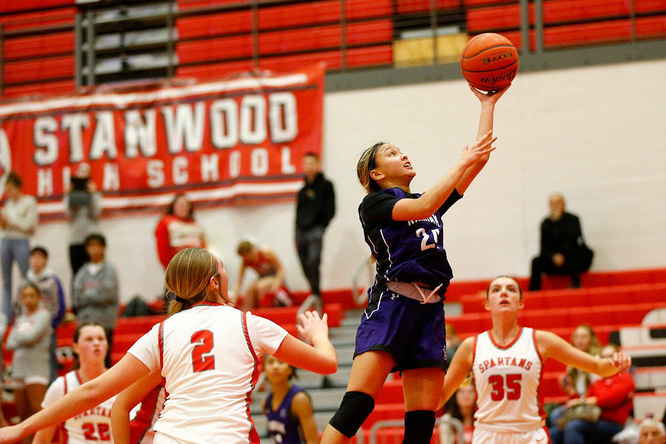 Kamiak’s Bella Hasan finishes at the rim with a driving layup against Stanwood on Thursday, Nov. 30, 2023, at Stanwood High School in Stanwood, Washington. (Ryan Berry / The Herald)