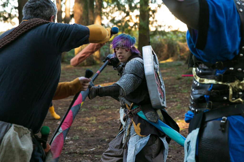 Dane Pischke, persona Matrix, tries to fend off a couple attackers during a warmup round of “heavy object” at a weekly meeting of the Amtgard LARPing group The Hollow on Jan. 29, 2023, at McCollum Park. (Ryan Berry / The Herald)
