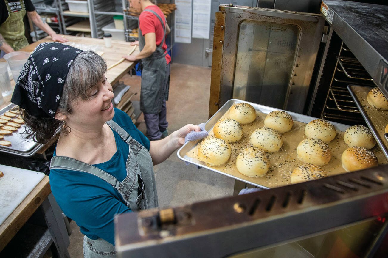 General manager and chef Allyss Taylor, 42, removes bread  from an oven at Seabiscuit Bakery in Langley, Washington on Thursday, Jan. 12, 2023.  (Annie Barker / The Herald)