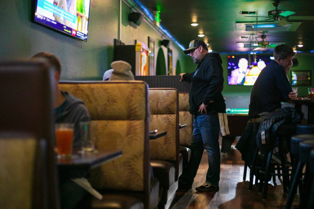 Bartender Hunter Haynes chats with a few customers before taking their order at Cole’s Tavern in Mukilteo. (Ryan Berry / The Herald)
