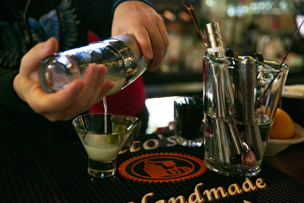 Bartender Hunter Haynes pours a dirty martini while working at Cole’s Tavern. (Ryan Berry / The Herald)
