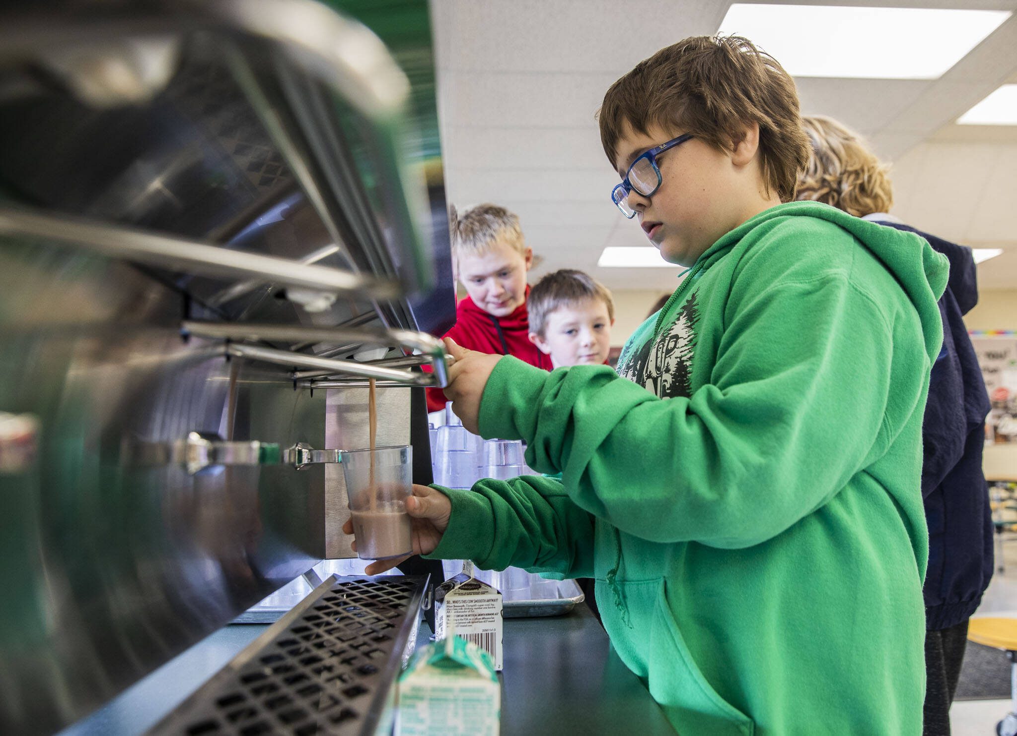 Darrington Elementary School fourth grader Brayden Parris, 9, fills up his cup with chocolate milk from one of the schools new milk dispenser during lunch on Monday, Nov. 20, 2023 in Darrington, Washington. (Olivia Vanni / The Herald)