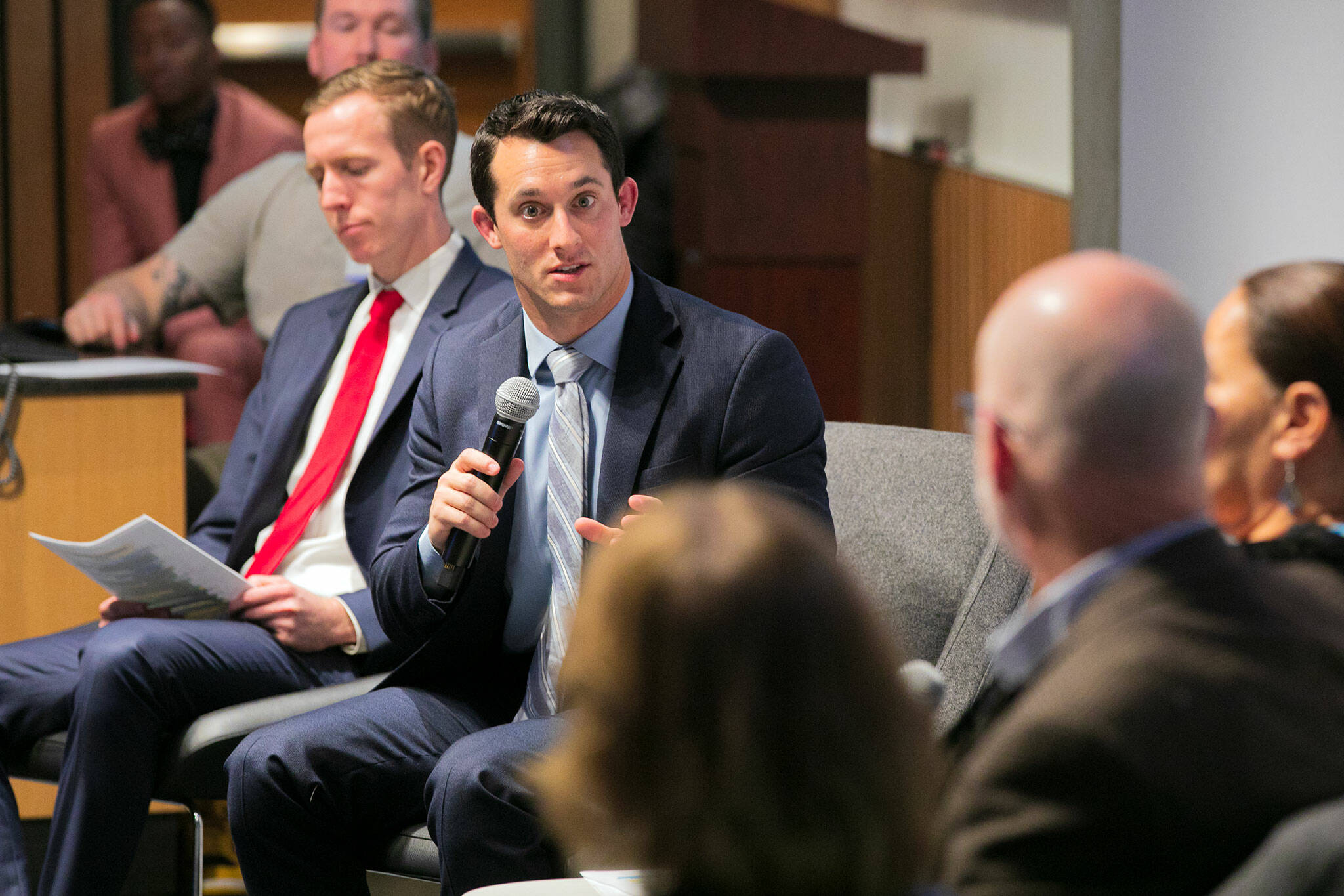 Snohomish County Councilmembers Nate Nehring, left, and Jared Mead, speaking, take turns moderating a panel including Tulip Tribes Chairwoman Teri Gobin, Stanwood Mayor Sid Roberts and Lynnwood Mayor Christine Frizzell during the Building Bridges Summit on Monday, Dec. 4, 2023, at Washington State University Everett in Everett, Washington. (Ryan Berry / The Herald)