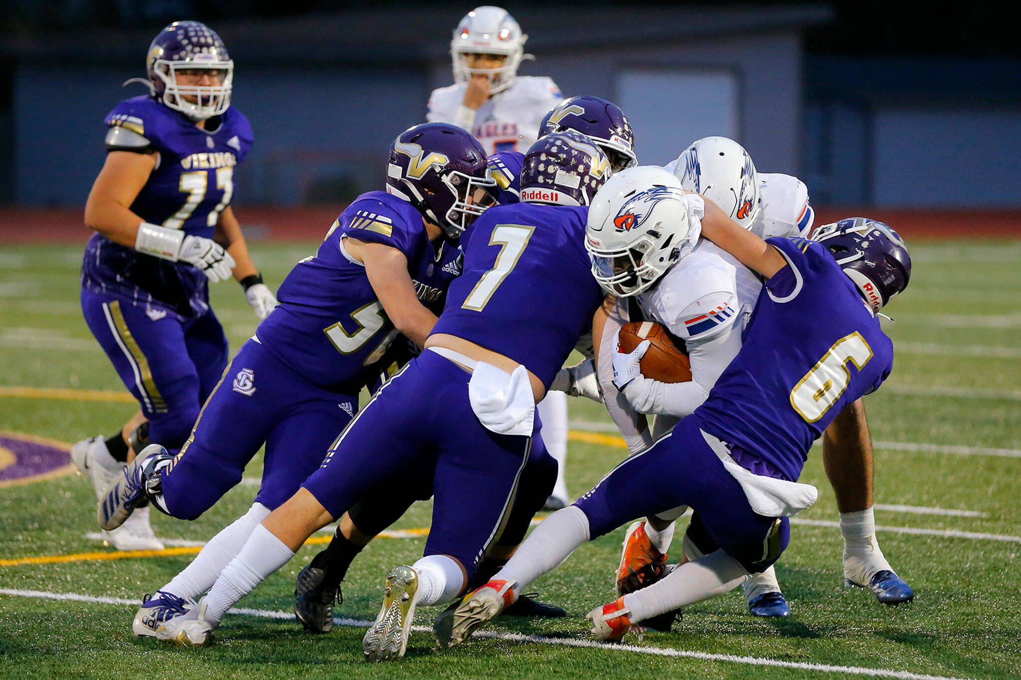 A gang of Lake Stevens Vikings take down the ball carrier during a Class 4A state semifinal game against Graham-Kapowsin on Nov. 26, 2022, in Lake Stevens. (Ryan Berry / The Herald)