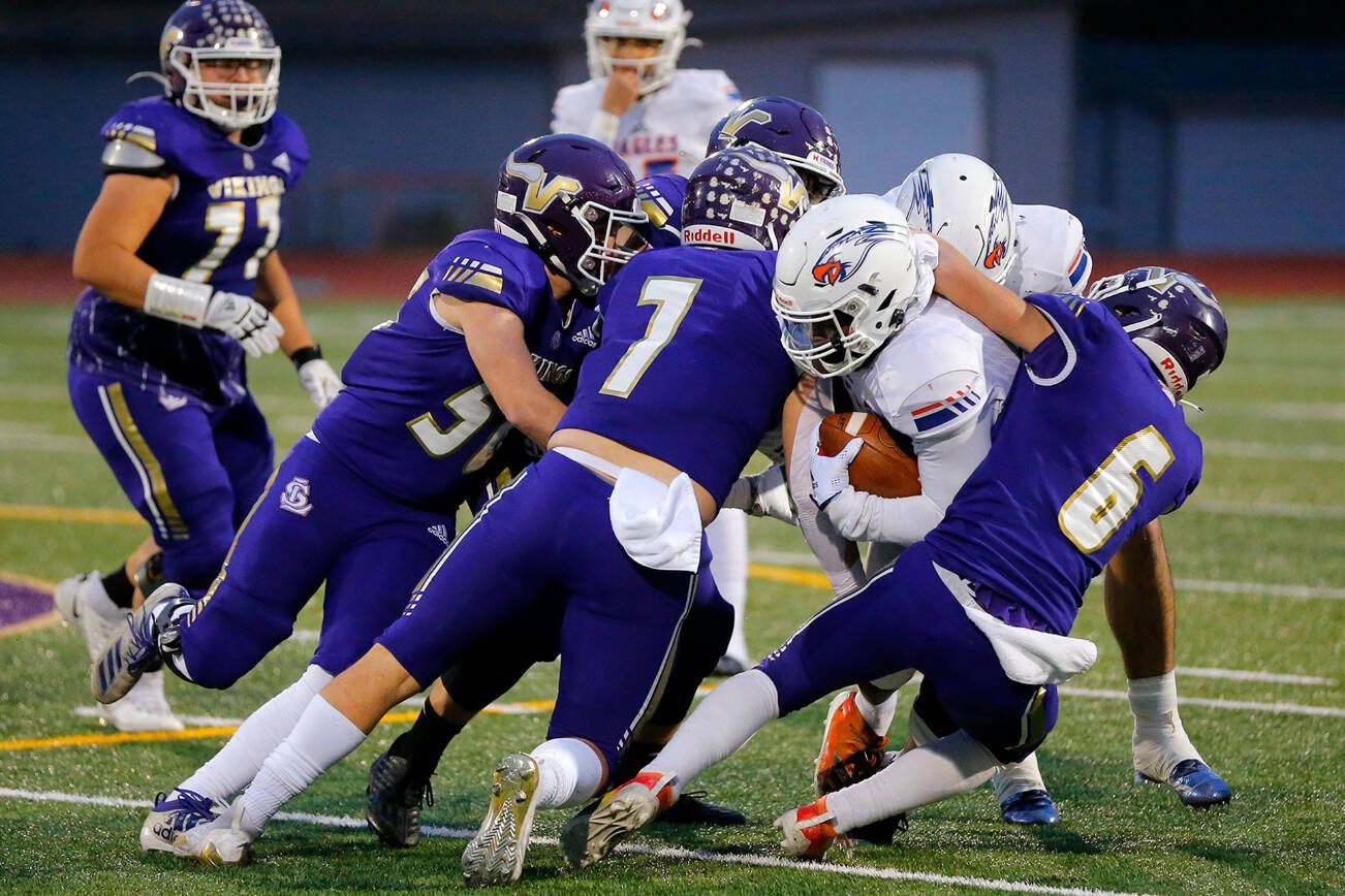 A gang of Lake Stevens Vikings take down the ball carrier during the 4A semifinal against Graham-Kapowsin on Saturday, Nov. 26, 2022, at Lake Stevens High School in Lake Stevens, Washington. (Ryan Berry / The Herald)