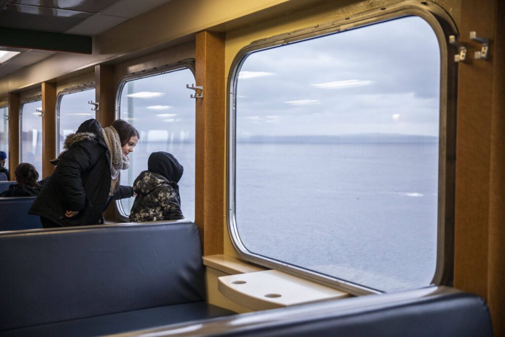 People look out the window from inside the M/V Kitsap on Friday, Dec. 1, 2023 in Mukilteo, Washington. (Olivia Vanni / The Herald)
