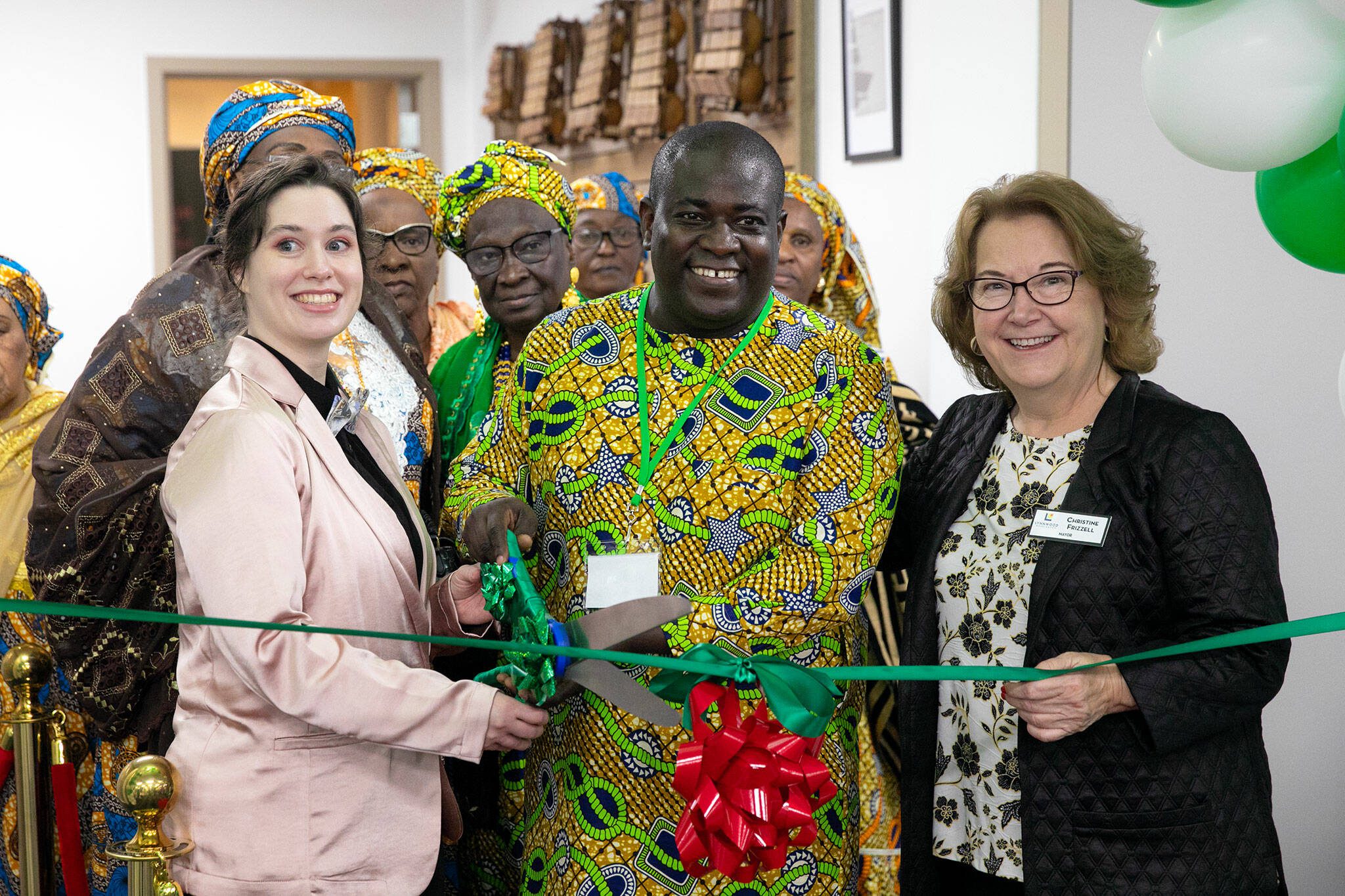 Founder and Executive Director Pa Ousman Joof, alongside Lynnwood Mayor Christine Frizzell, right, prepares to cut the ribbon during the grand opening of the Washington West African Center on Saturday, Dec. 2, 2023, in Lynnwood, Washington. (Ryan Berry / The Herald)