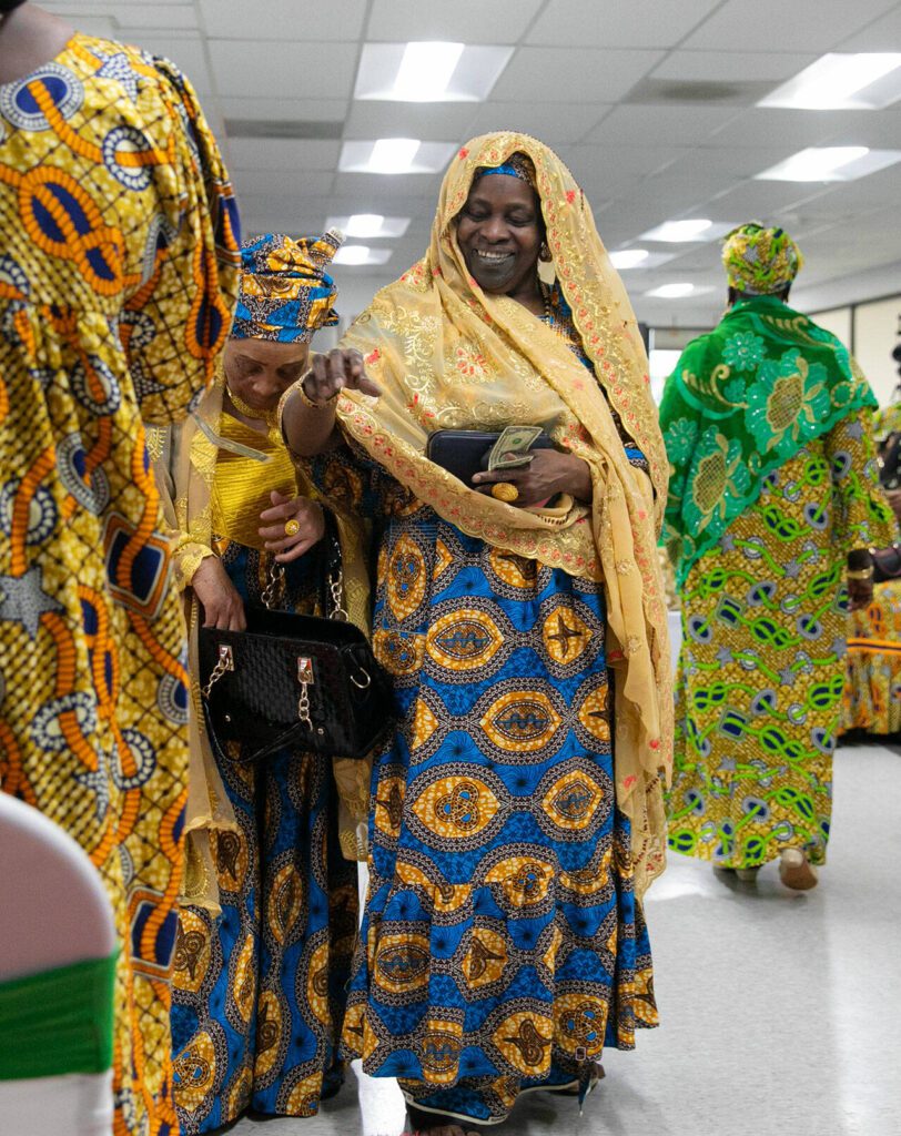 Grandmas take turns donating money during a song at the grand opening of the Washington West African Center on Saturday, Dec. 2, 2023, in Lynnwood, Washington. (Ryan Berry / The Herald)
