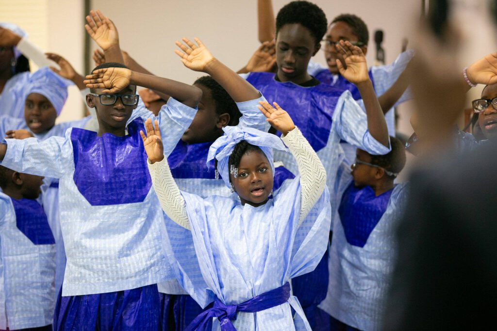 Children from the Bideww Choir sing and dance during the grand opening of the Washington West African Center on Saturday, Dec. 2, 2023, in Lynnwood, Washington. (Ryan Berry / The Herald)
