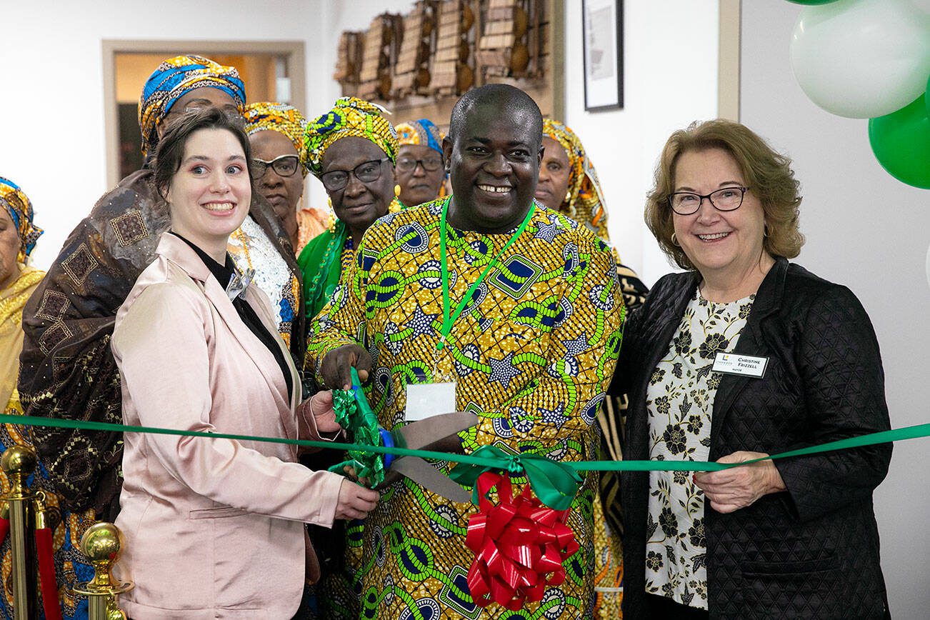 Founder and Executive Director Pa Ousman Joof, alongside Lynnwood Mayor Christine Frizzell, right, prepares to cut the ribbon during the grand opening of the Washington West African Center on Saturday, Dec. 2, 2023, in Lynnwood, Washington. (Ryan Berry / The Herald)