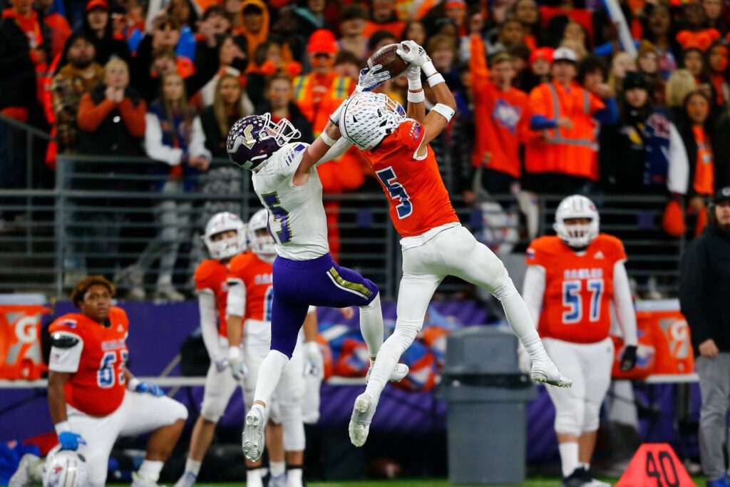 Lake Stevens’ Jesse Lewis and Graham-Kapowsin’s Mika Roberson both reach for a pass during the WIAA 4A Football State Championship on Saturday, Dec. 2, 2023, at Husky Stadium in Seattle, Washington. (Ryan Berry / The Herald)
