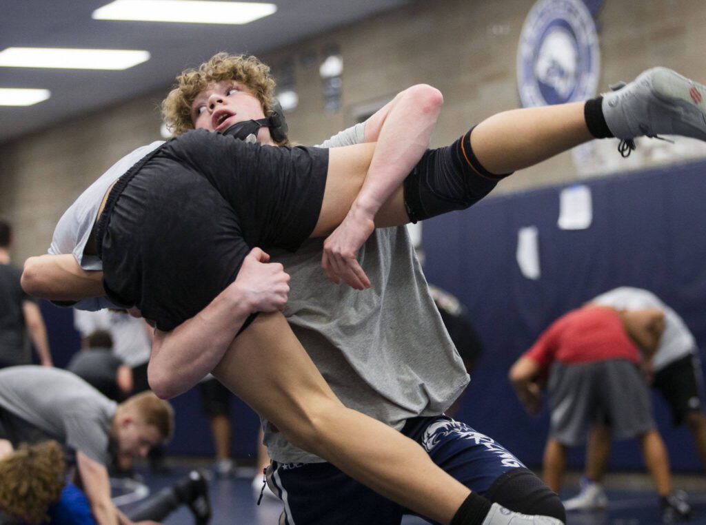 Arlington sophomore Beau Gudde lifts a teammate during practice Nov. 29 in Arlington. (Olivia Vanni / The Herald)

