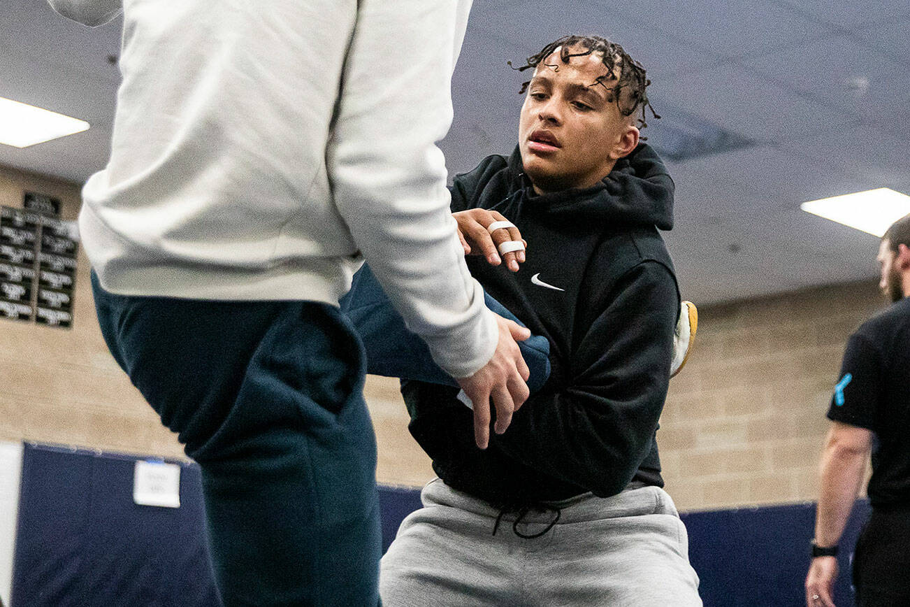 Arlington sophomore wrestler Tre Haines grabs the leg of his teammate during practice on Wednesday, Nov. 29, 2023 in Arlington, Washington. (Olivia Vanni / The Herald)