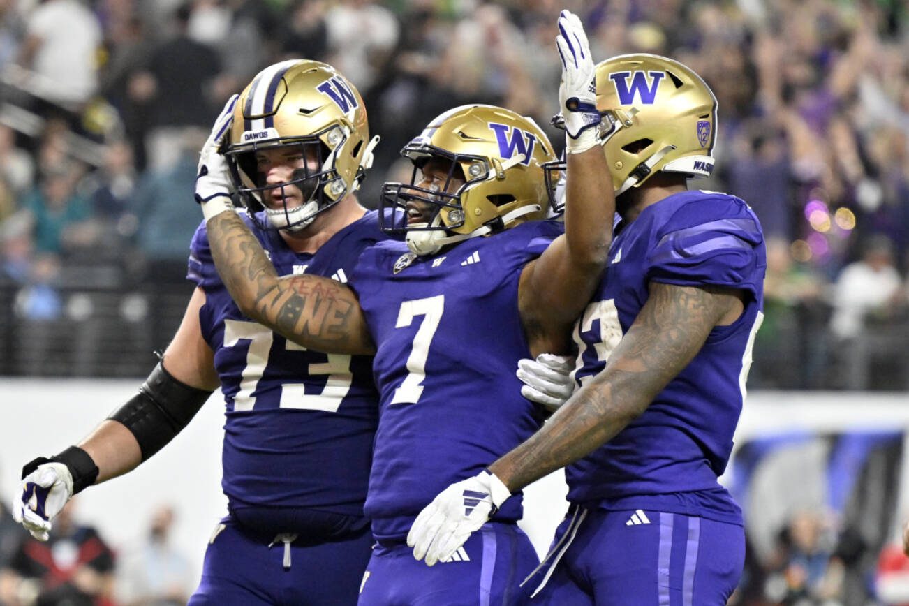 Washington running back Dillon Johnson (7) celebrates with teammates after a touchdown against Oregon during the second half of the Pac-12 championship NCAA college football game Friday, Dec. 1, 2023, in Las Vegas. (AP Photo/David Becker)