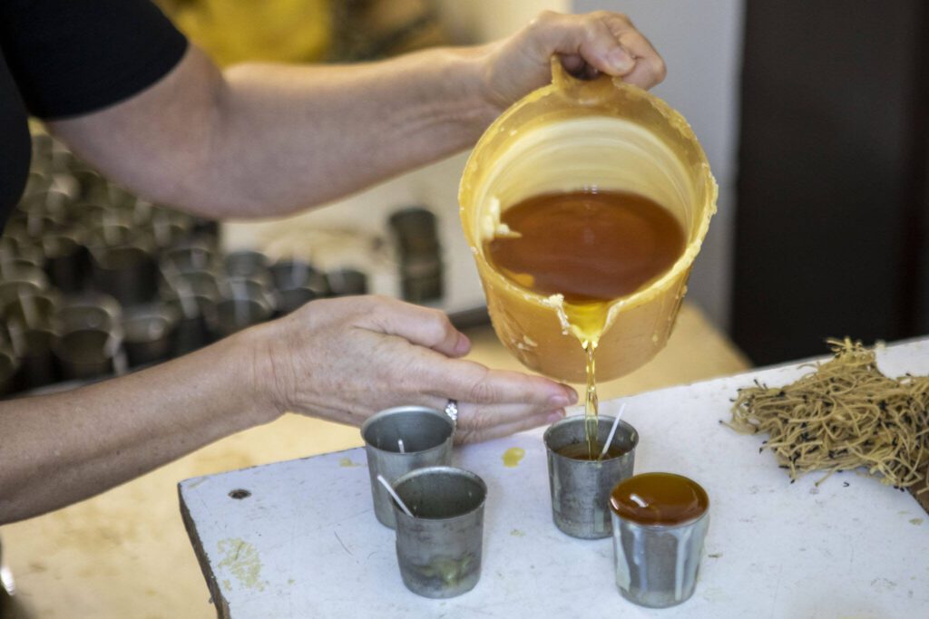 Katherine Hopke pours candles for her business Golden Light Beeswax Candles at her home in Everett, Washington on Thursday, Nov. 30, 2023. (Annie Barker / The Herald)
