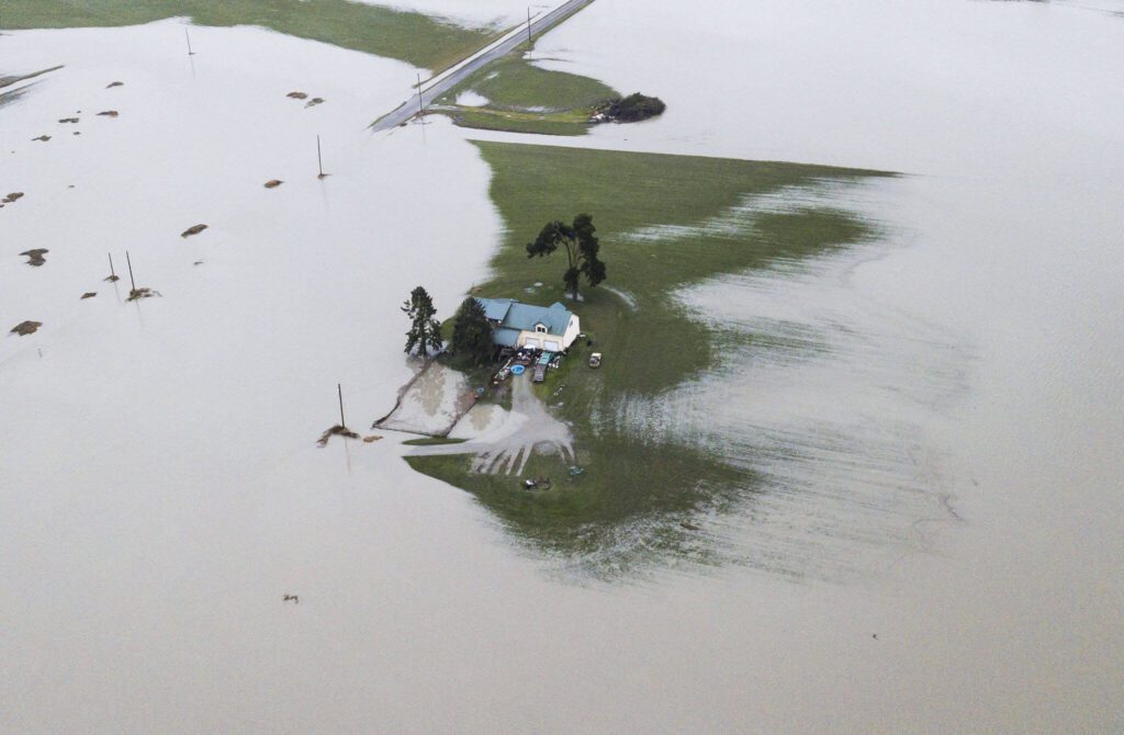 A house is completely surrounded by floodwater along Pioneer Highway on Wednesday, Dec. 6, 2023 in Stanwood, Washington. (Olivia Vanni / The Herald)
