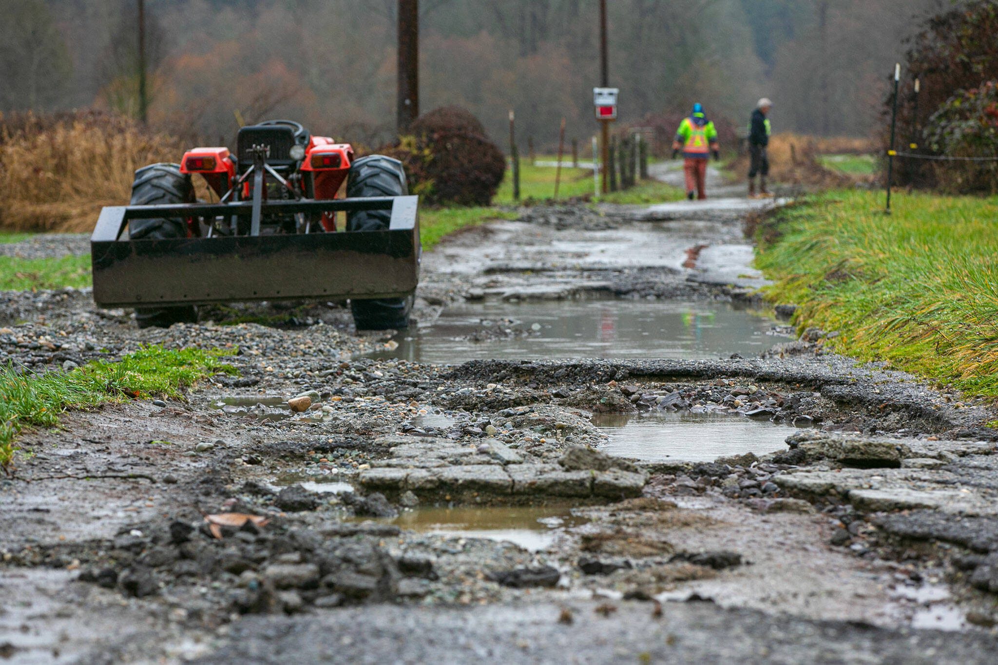 The drive up to Mary Fuentes’ farm is washed out and full of potholes on Thursday, Dec. 7, 2023, after extensive flooding from the Stillaguamish River in Silvana, Washington. Fuentes was unable to drive out of her property due to the damage, but is within walking distance of her brother’s house. (Ryan Berry / The Herald)