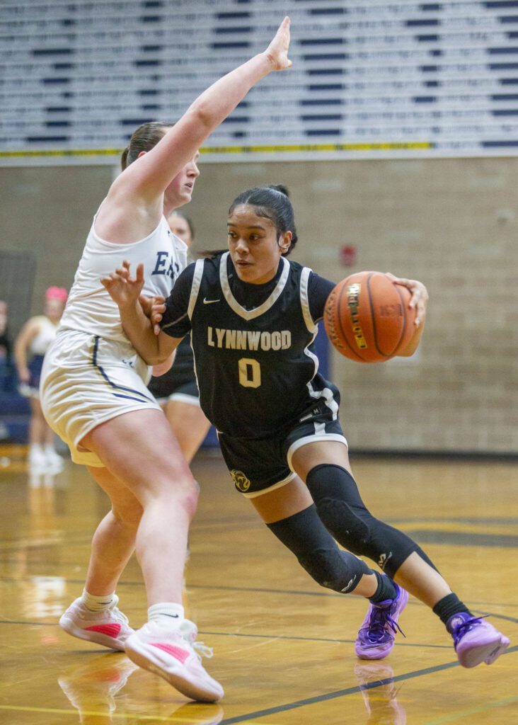 Lynnwood’s Aniya Hooker tries to get to the basket while being guarded by Arlington’s Katie Snow during the game on Monday, Dec. 11, 2023 in Arlington, Washington. (Olivia Vanni / The Herald)
