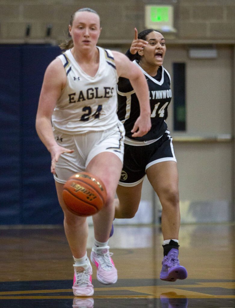 Lynnwood’s Dina Yonas yells at teammates to mark up while Arlington’s Katie Snow takes the ball down the court during the game on Monday, Dec. 11, 2023 in Arlington, Washington. (Olivia Vanni / The Herald)
